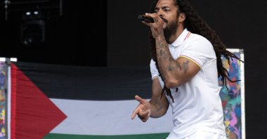 Backdropped by a Palestinian flag, Bobby Vylan of the British duo Bob Vylan performs on the West Holts Stage on the fourth day of the Glastonbury festival at Worthy Farm in the village of Pilton, Somerset, southwest U.K., June 28, 2025. (AFP Photo)