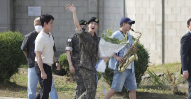 K-pop band BTS&#039;s member Jin (C) waves after being discharged from a mandatory military service outside of an army base in Yeoncheon, South Korea, June 12, 2024. (AP Photo)