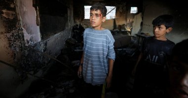 An injured boy looks on as Palestinians inspect the damage at a school sheltering displaced people, following an overnight Israeli airstrike, in Gaza City, Palestine, July 3, 2025. (Reuters Photo)