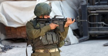 An Israeli soldier aims his weapon during a military raid in Nablus, occupied West Bank, July 2, 2025. (EPA Photo)