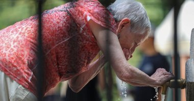A woman cools off at a fountain at Retiro park during a heat wave, Madrid, Spain, July 1, 2025. (Reuters Photo)