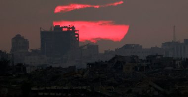 This picture taken from a position at Israel&#039;s border with the Gaza Strip shows the sun setting behind destroyed buildings in the besieged Palestinian territory, July 3, 2025. (AFP Photo)