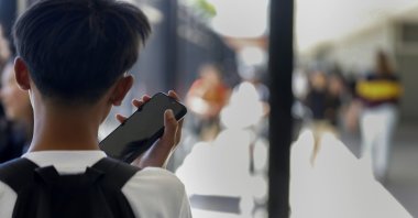 A student uses their cell phone after unlocking the pouch that secures it from use during the school day at Bayside Academy, San Mateo, California, U.S., Aug. 16, 2024. (AP File Photo)