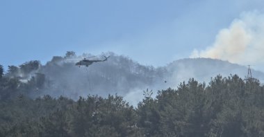 A firefighting helicopter makes a water drop during a wildfire in the town of Dörtyol, near Hatay, Türkiye, July 5, 2025. (DHA Photo)