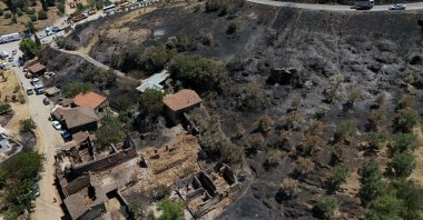 An aerial view shows scorched forestland, homes and barns damaged by the wildfire in the Ödemiş district, Izmir, Türkiye, July 6, 2025. (AA Photo)
