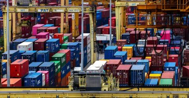 A man rides a motorcycle past containers at a port, following the announcement that U.S. President Donald Trump would impose tariffs of 36% on goods from Thailand, Bangkok, Thailand, July 8, 2025. (Reuters Photo)