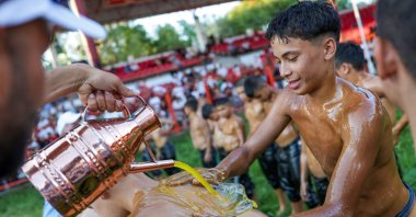 A young wrestler coats a fellow participant in oil before competing in the 664th annual Kirkpinar Oil Wrestling Festival, one of the oldest continuously running sports events in the world, at the historic Sarayici Arena, Edirne, Türkiye, July 4, 2025. (Reuters Photo)
