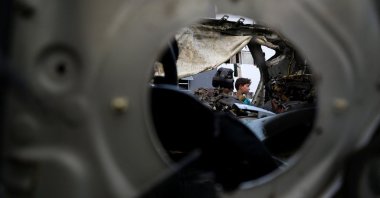 A Palestinian child looks on next to a car hit in an Israeli strike Monday, in Gaza City, Palestine, July 8, 2025. (Reuters Photo)