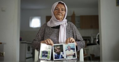 Saliha Osmanovic, 71, poses for a photo while holding pictures of her two sons and husband, victims of the Srebrenica genocide in the village of Dobrak near Srebrenica, Bosnia, June 28, 2025. (AP Photo)