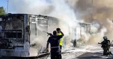Firefighters and emergency teams work to control the blaze on the burnt metrobus near the Incirli stop in Bakırköy, Istanbul, Türkiye, July 7, 2025. (AA Photo)