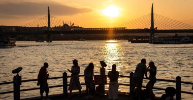 People walk along the Galata Bridge in the Golden Horn, Istanbul, Türkiye, June 16, 2024. (AFP Photo)