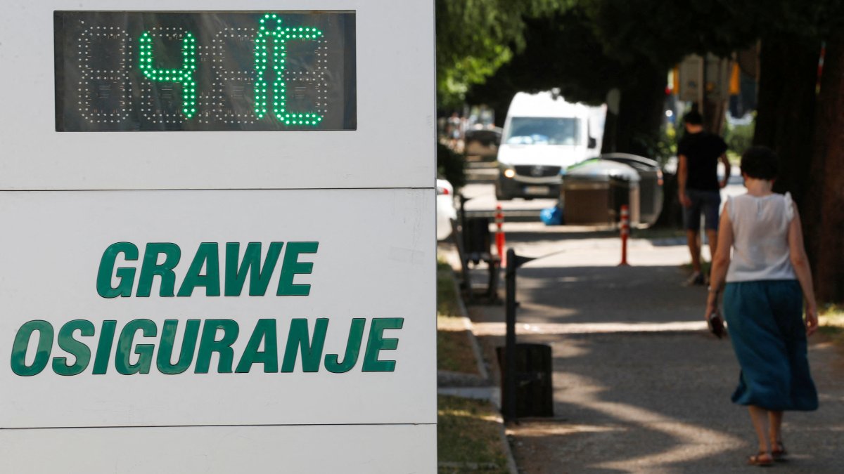 A woman passes a street thermometer showing 41 degrees Celsius as residents and tourists seek relief from scorching temperatures in the past two days, as a heat wave gripped the Balkan region, Podgorica, Montenegro, July 3, 2025. (Reuters Photo)