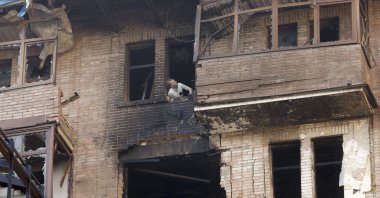 A man looks out of a broken window at the site of a drone strike, amid the ongoing Russian invasion, in Kyiv, Ukraine, July 10, 2025. (EPA Photo)