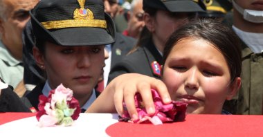 Hatice Kübra Yaman (R) leaves flowers on the casket of her father, Enver Yaman, who was martyred in northern Iraq, during his funeral, in central Niğde province, Türkiye, July 8, 2025. (AA Photo)
