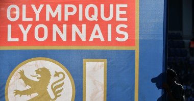 A pedestrian walks past a flag with the logo of Olympique Lyonnais (OL) during the French Ligue 1 football match between Toulouse FC (TFC) and OL at the Municipal Stadium, Toulouse, France, Oct. 29, 2016. (AFP Photo)
