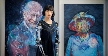 Ultra-realistic humanoid artist robot Ai-Da looks on in front of paintings of Britain&#039;s King Charles III and Queen Elizabeth II, displayed on the sidelines of the AI for Good Global Summit organized by International Telecommunication Union (ITU), Geneva, Switzerland, July 9, 2025. (AFP Photo)