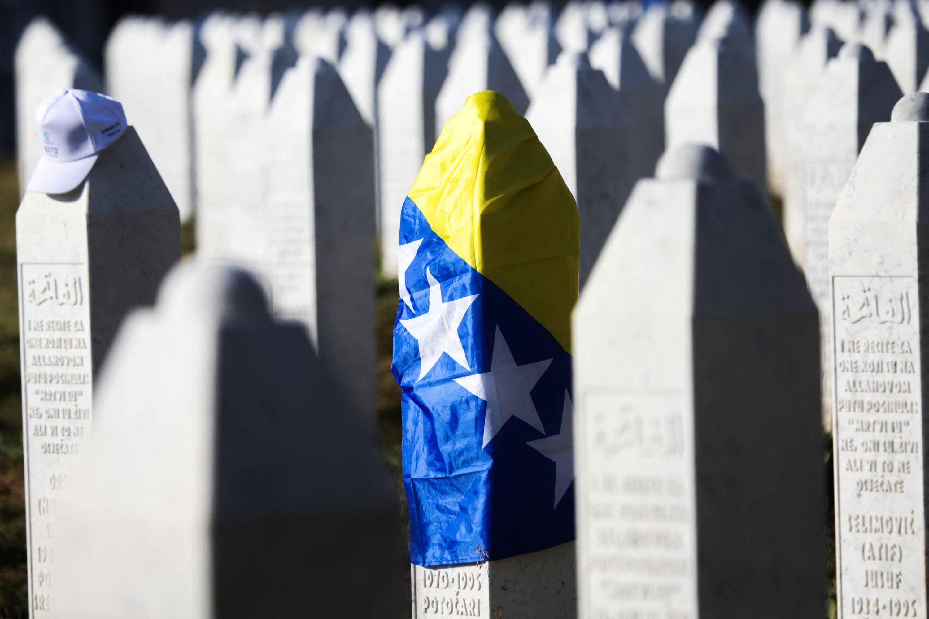 A grave stone is wrapped with a flag of Bosnia and Herzegovina as it stands amid other grave stones of victims killed during the Srebrenica genocide, at the memorial cemetery in the village of Potocari, near the eastern town of Srebrenica, Bosnia-Herzegovina, July 11, 2025. (Reuters Photo)
