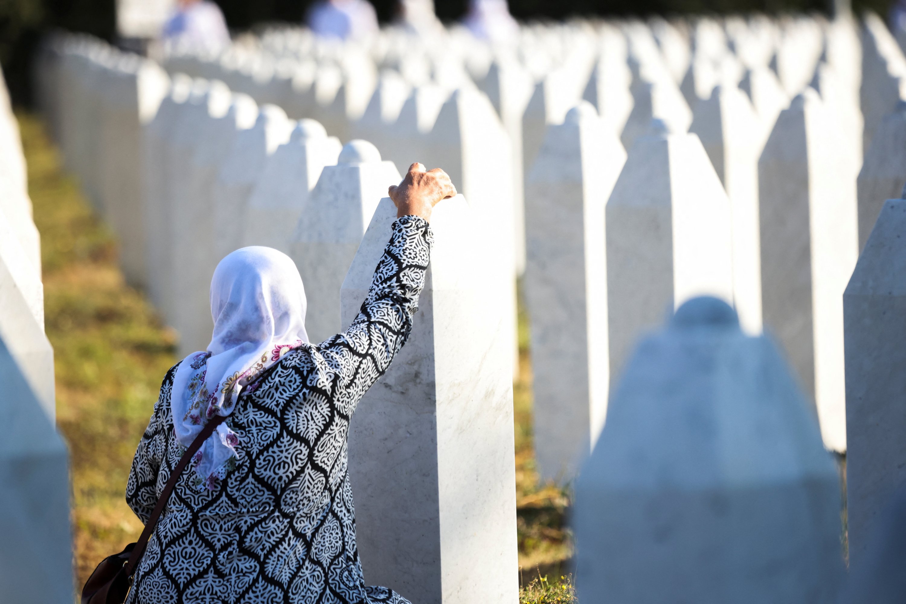 A Bosnian Muslim woman stands amid grave stones of victims killed during the Srebrenica genocide, at the memorial cemetery in the village of Potocari, near the eastern town of Srebrenica, Bosnia-Herzegovina, July 11, 2025. (Reuters Photo)