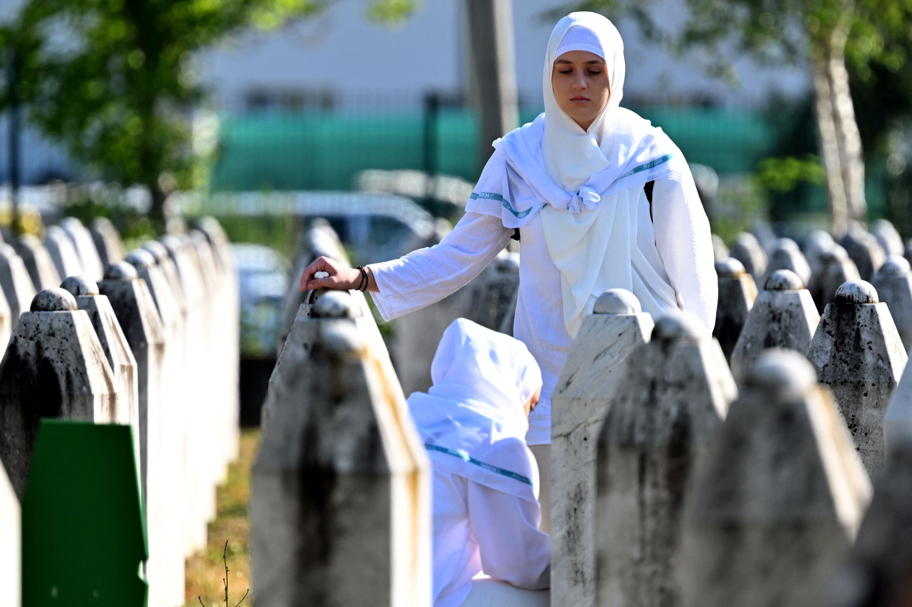 A Bosnian Muslim woman touches grave stones as she visits the graves of her relatives at the memorial cemetery in the village of Potocari, near the eastern town of Srebrenica, Bosnia-Herzegovina, July 11, 2025. (AFP Photo)