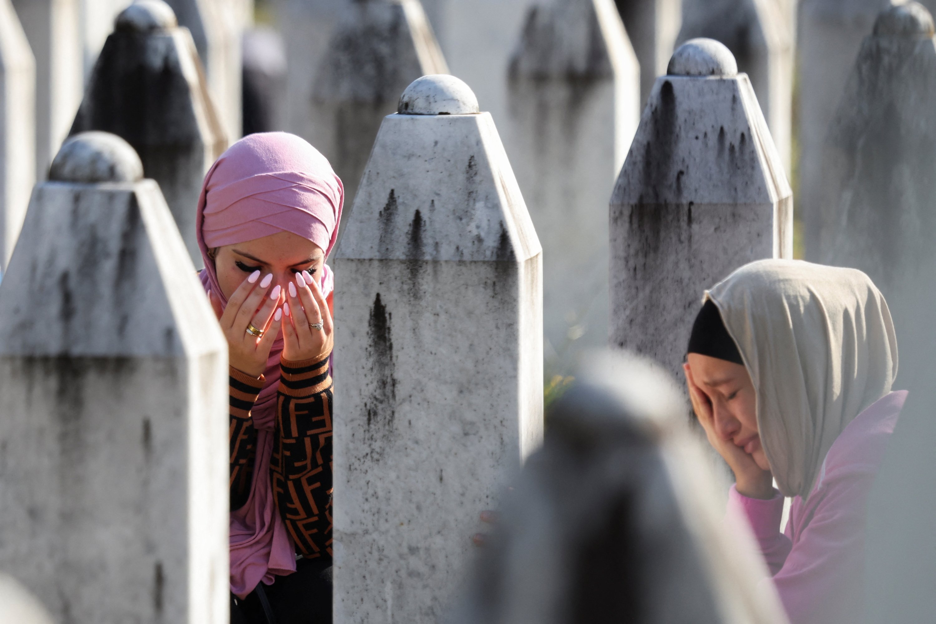 Bosnian Muslim women react amid the grave stones of victims killed during the Srebrenica genocide, at the memorial cemetery in the village of Potocari, near the eastern town of Srebrenica, Bosnia-Herzegovina, July 11, 2025. (Reuters Photo)