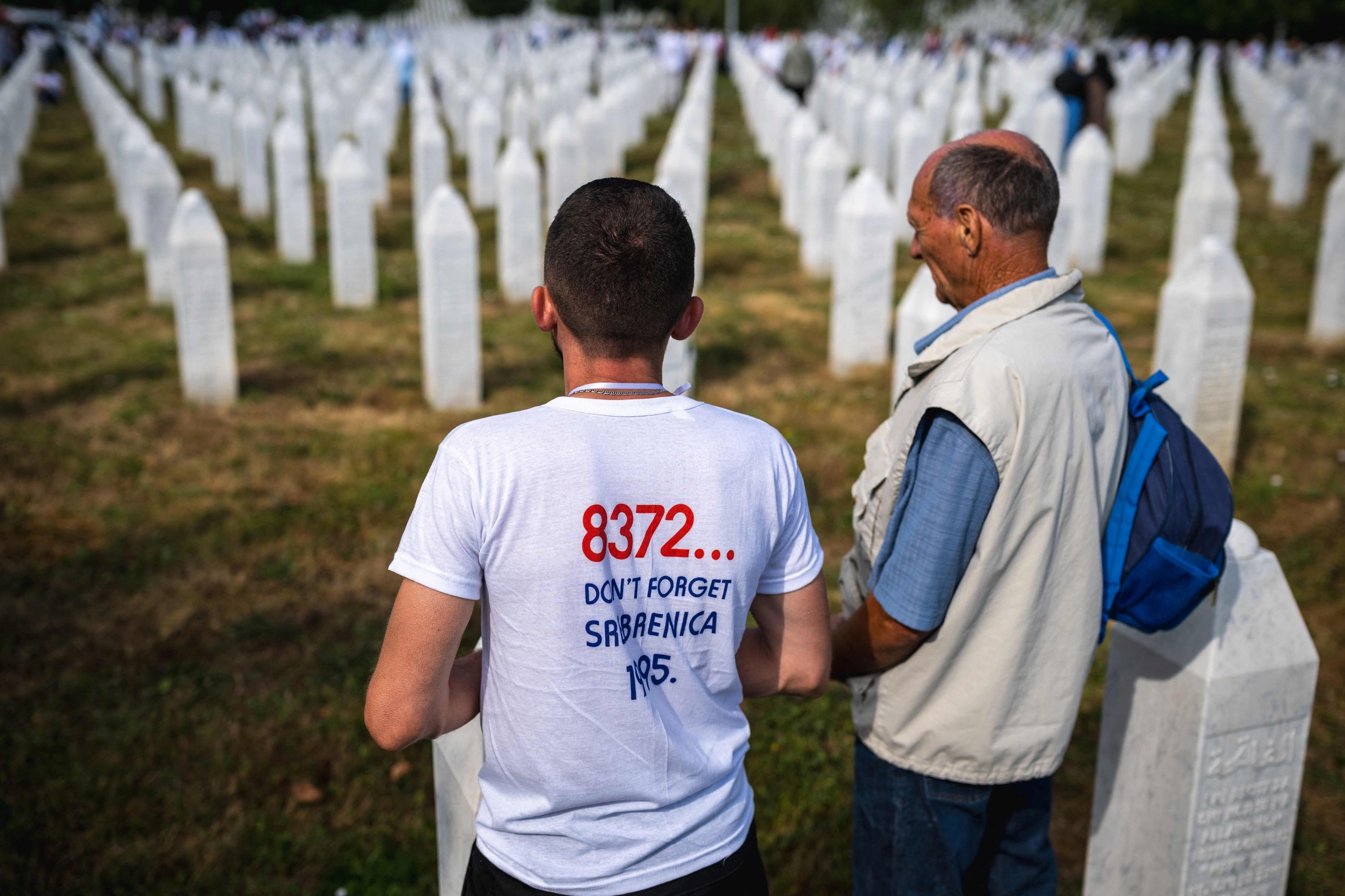 People stand in front of grave stones at the memorial cemetery in the village of Potocari, near the eastern Bosnian town of Srebrenica, July 11, 2025. (AFP Photo)