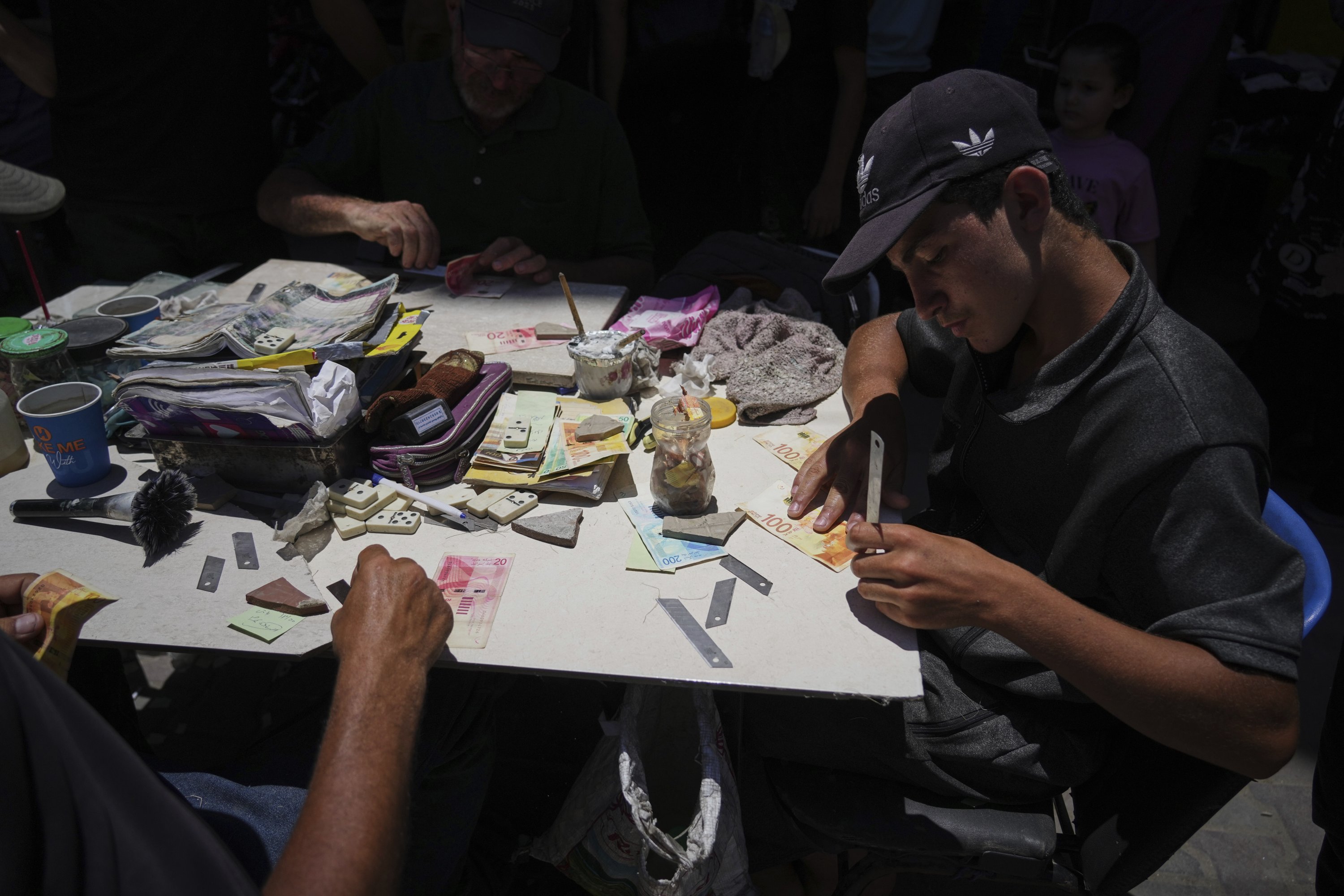 People repair worn-out Israeli currency, Gaza City, Palestine, July 9, 2025. (AP Photo)