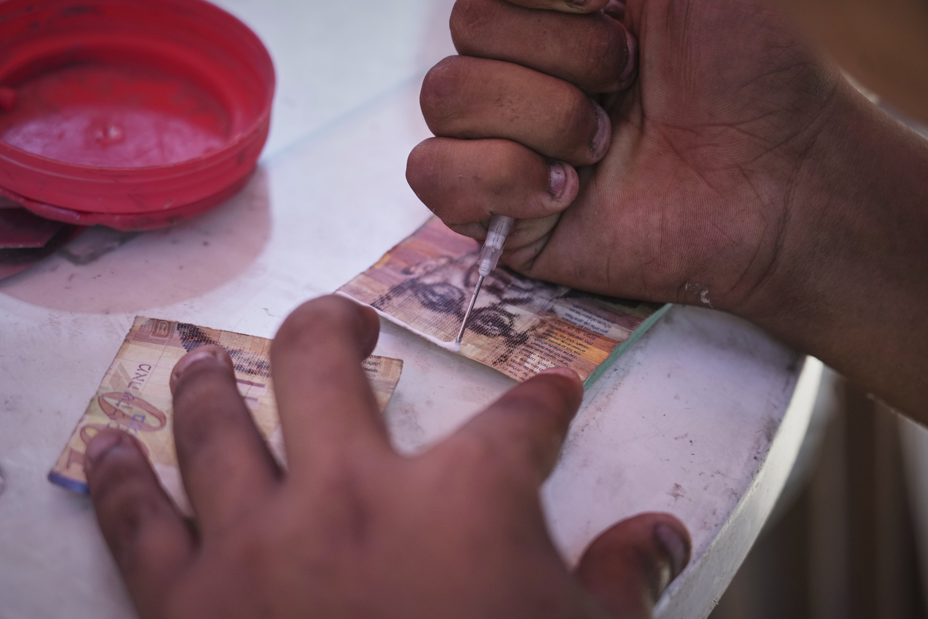 A Palestinian man repairs worn-out Israeli currency, Gaza City, Palestine, July 9, 2025. (AP Photo)