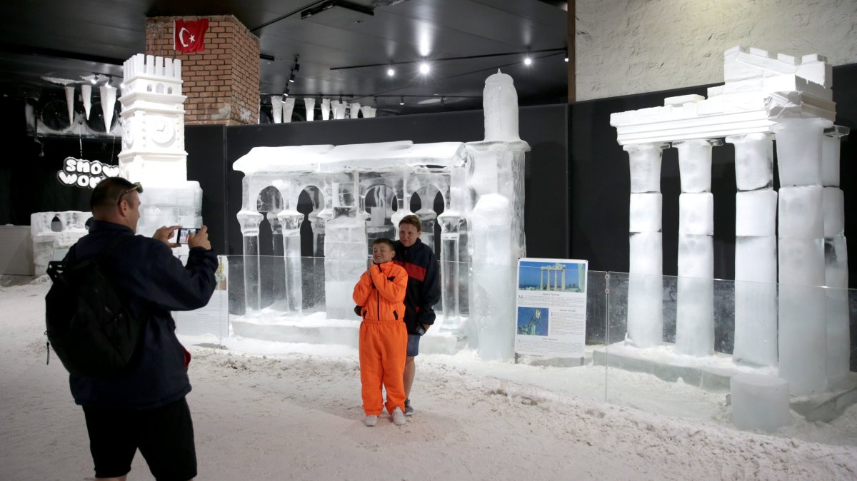 Visitors take photos with the ice sculpture of the Temple of Apollo at the Snow World and Ice Museum, Antalya, Türkiye, June 25, 2025. (AA Photo)