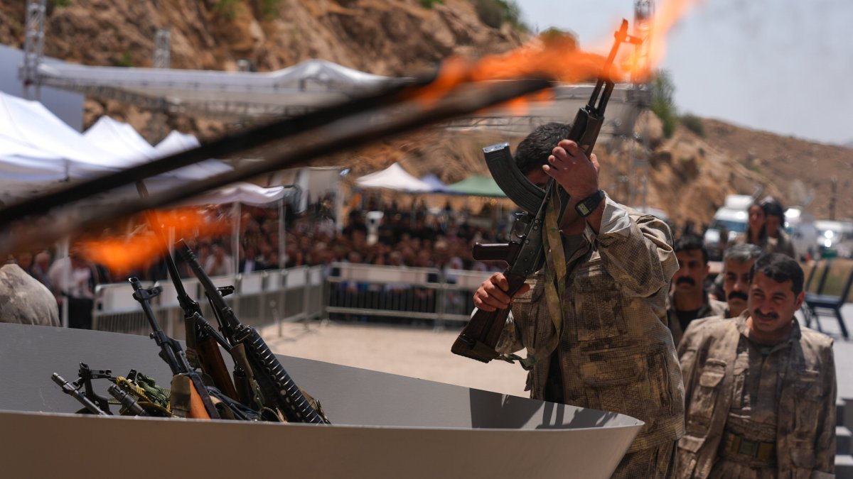 A PKK terrorist puts his weapon into a pit during the disarmament ceremony, in the city of Sulaymaniyah, Iraq, July 11, 2025. (AA Photo)