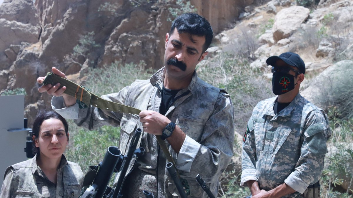A PKK terrorist puts his weapon into a pit during the disarmament ceremony, in the city of Sulaymaniyah, Iraq, July 11, 2025. (AFP Photo)
