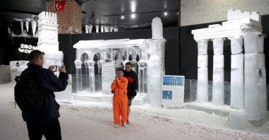 Visitors take photos with the ice sculpture of the Temple of Apollo at the Snow World and Ice Museum, Antalya, Türkiye, June 25, 2025. (AA Photo)