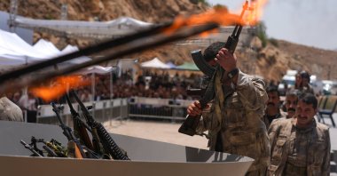 A PKK terrorist puts his weapon into a pit during the disarmament ceremony, in the city of Sulaymaniyah, Iraq, July 11, 2025. (AA Photo)