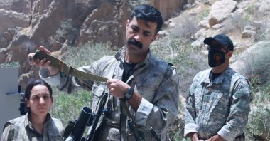 A PKK terrorist puts his weapon into a pit during the disarmament ceremony, in the city of Sulaymaniyah, Iraq, July 11, 2025. (AFP Photo)

