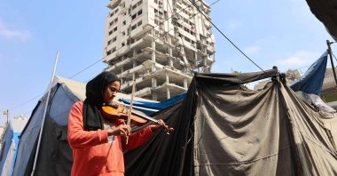 A student plays the violin during a music class in a camp for displaced Palestinians in the northern Al-Rimal neighborhood, Gaza City, Palestine, July 10, 2025. (AFP Photo)