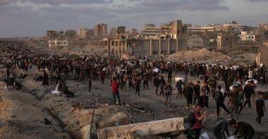 Displaced Palestinians carry bags of flour along Rashid Street in western Jabalia, June 17, 2025. (EPA Photo)