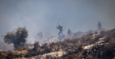 Masked Israeli settlers hurl rocks at Palestinians from hilltop in the village of Sinjil, in the occupied West Bank, Palestine, July 4, 2025. (AFP Photo)