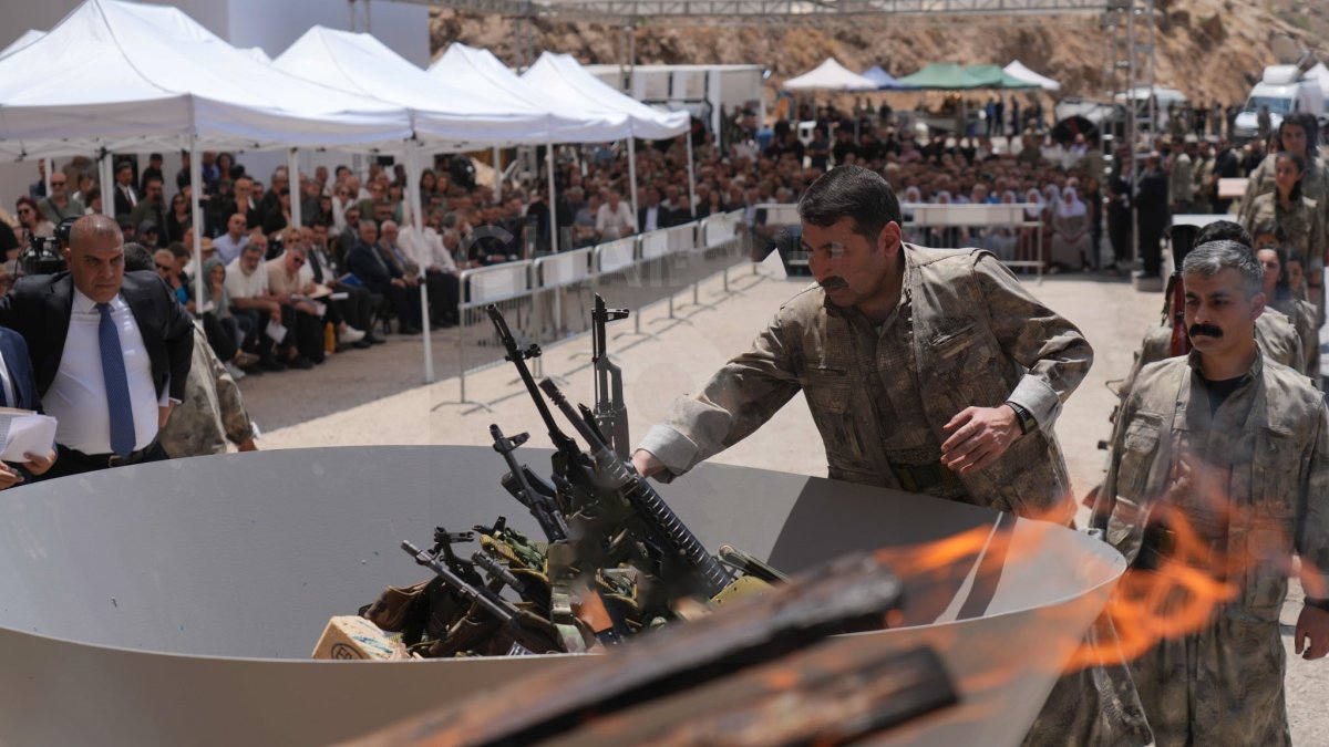 The first group of PKK terrorist members placing their weapons into a cauldron to be burned, Sulaymaniyah, northern Iraq, July 11, 2025. (IHA Photo)