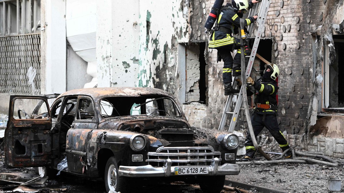Firefighters are seen next to a burnt-out car following mass Russian drone and missile strikes, in Lviv, western Ukraine, July 12, 2025. (AFP Photo)