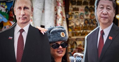 A tourist wearing a Soviet Army hat poses with cardboard images depicting Russian President Vladimir Putin and his Chinese counterpart Xi Jinping at the touristic Arbat Street, Moscow, Russia, June 24, 2025. (AFP Photo)