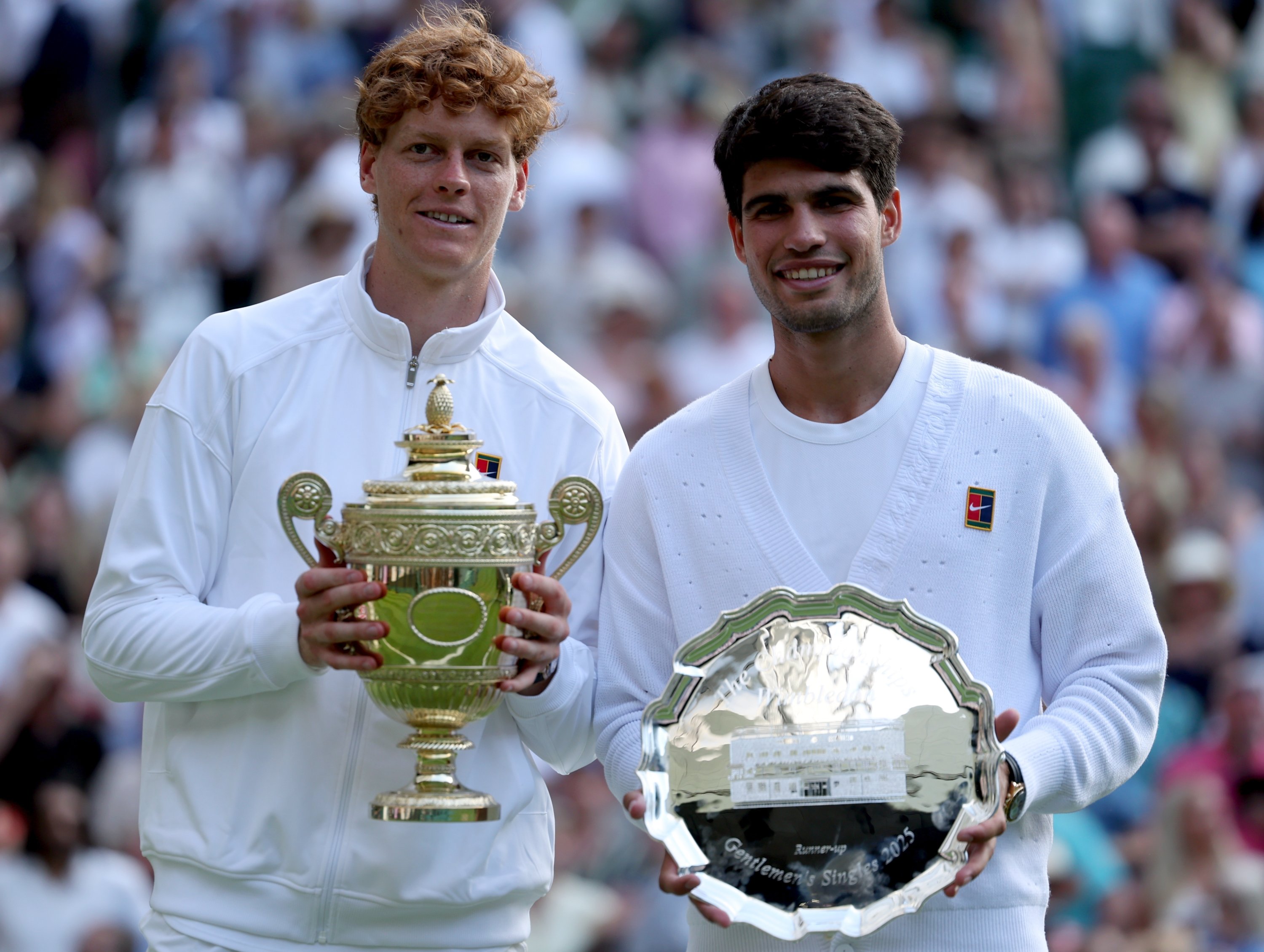 Italy's Jannik Sinner (L) celebrates with the trophy after winning the men's singles final match against Spain's Carlos Alcaraz with his runner-up trophy at the Wimbledon Championships, London, U.K., July 13, 2025. (EPA Photo)
