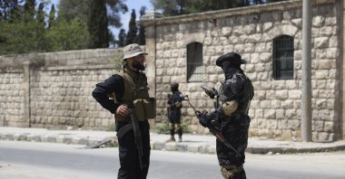 A member of the government security forces (L) speaks with a YPG terrorist during a prisoner exchange, Aleppo, Syria, June 2, 2025. (AP Photo)