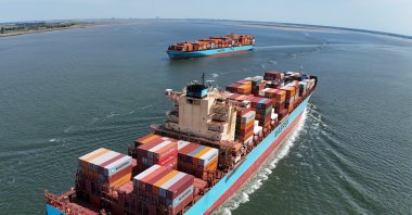 A container ship arriving from Norfolk Harbour, U.S., en route to Antwerp Harbor, and a ship (L) sailing after departing from Antwerp Harbor, Hansweert, Netherlands, June 20, 2025. (EPA Photo)