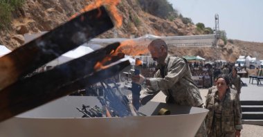 The first group of PKK terrorist members place their weapons into a cauldron to be burned, Sulaymaniyah, northern Iraq, July 11, 2025. (İHA Photo)