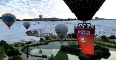 Hot air balloons decorated with Turkish flags and banners soar over Pamukkale to mark July 15 Democracy and National Unity Day, Denizli, Türkiye, July 15, 2025. (AA Photo)