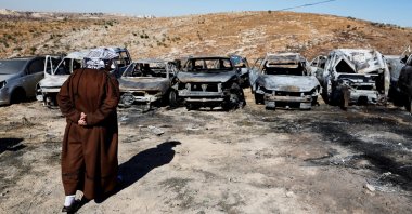 A Palestinian man inspects burnt cars, after Israeli settlers set fire to cars in the Palestinian town of Burqa, near Ramallah in the Israeli-Occupied West Bank, July 15, 2025. (Reuters Photo)