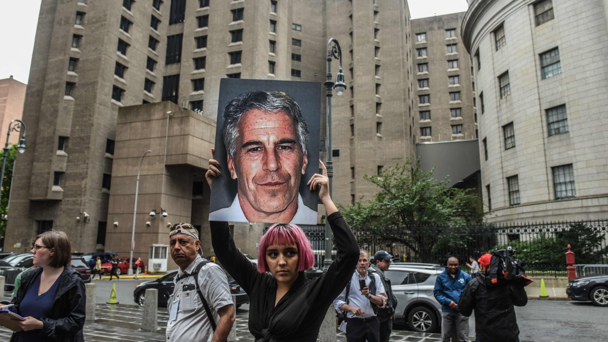 A member of a protest group called &quot;Hot Mess&quot; holds up a sign of Jeffrey Epstein in front of the Metropolitan Correction Center, New York City, U.S., July 8, 2019. (AFP Photo)