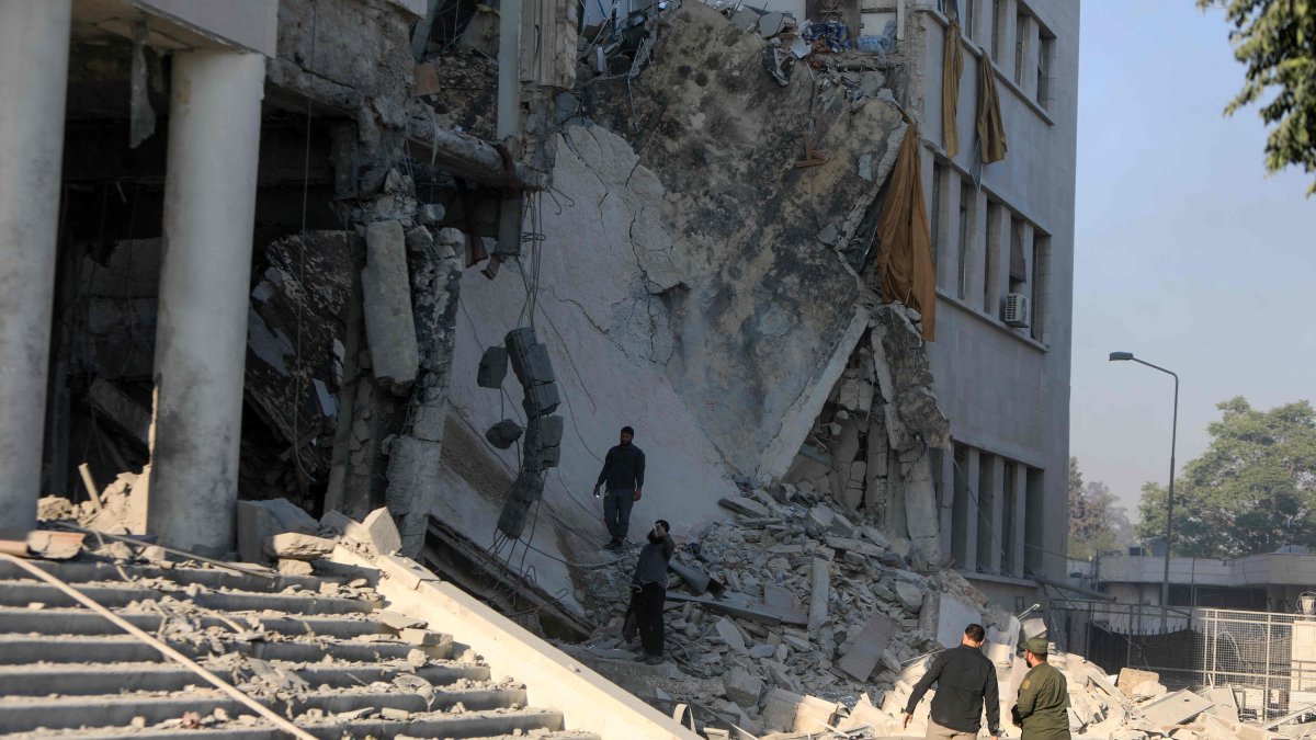 Members of the Syrian security forces assess the destruction inside the heavily damaged Syrian army and defense ministry headquarters complex in Damascus, following Israeli strikes, July 16, 2025. (AFP Photo)