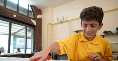 Nine-year-old Ertuğrul Yılmaz cuts katmer dough, Gaziantep, Türkiye, July 16, 2025. (IHA Photo)