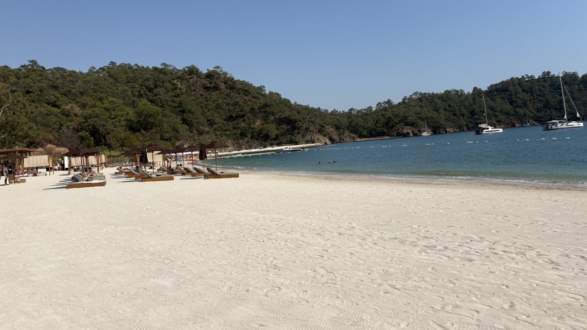 People sunbathe on the beach at Ahãma in Günlüklü Bay, Göcek, Muğla, southwestern Türkiye, July 17, 2025. (Courtesy of Funda Karayel)