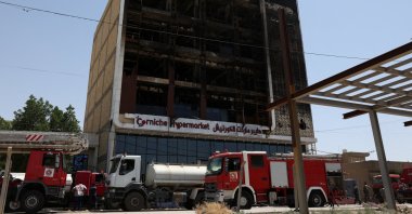 Fire trucks stand next to the wreckage of a shopping mall, after a massive overnight fire killed dozens of people, in Kut, Wasit province, Iraq, July 17, 2025. (Reuters Photo)